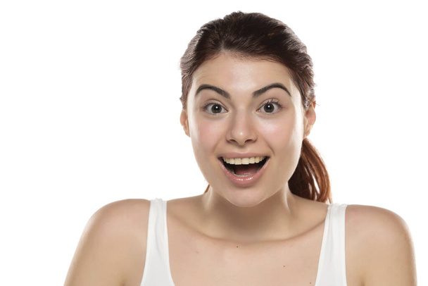 una giovane donna rossa felice senza trucco con i capelli lunghi su uno sfondo bianco studio - Foto, immagini