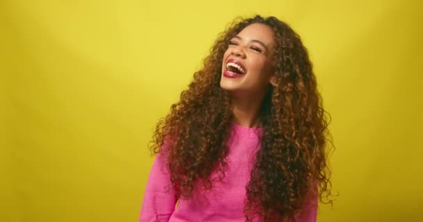 Smějící se mladá žena, multietnicky krásné, žluté pozadí studia. Vysoce kvalitní 4K záběry - Záběry, video