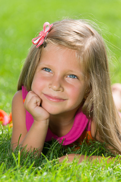 Kleines Mädchen liegt auf dem grünen Gras - Foto, Bild