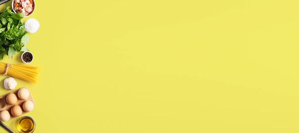 Ingredientes para una sabrosa pasta carbonara sobre fondo amarillo con espacio para texto - Foto, imagen