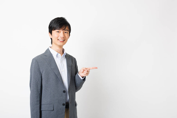 Young Japanese businessman in office attire showing pointing gesture - Photo, Image
