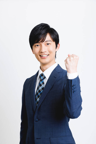 Young Japanese man in office attire showing cheering gesture on white background - Foto, Imagem