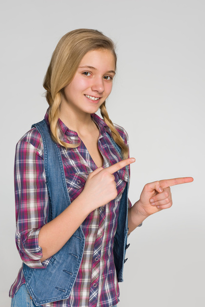 Ξανθιά κοπέλα δείχνει τα δάχτυλά της στο πλάι - Φωτογραφία, εικόνα