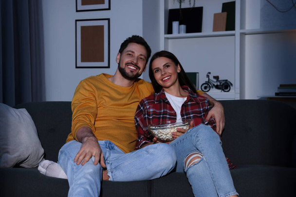 Happy couple watching TV at home in evening - Φωτογραφία, εικόνα