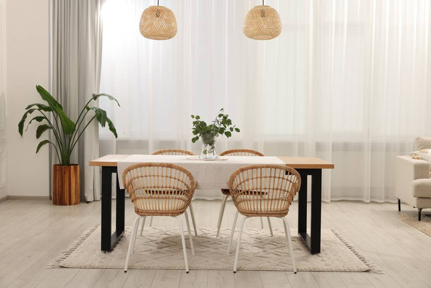 Stylish dining room with cozy furniture and plants - Фото, зображення