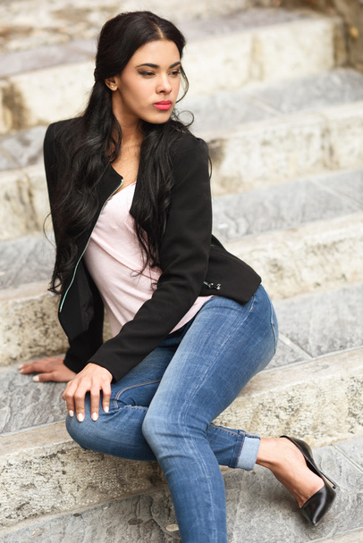 Hispanic jonge vrouw dragen casual kleding in stedelijke achtergrond - Foto, afbeelding