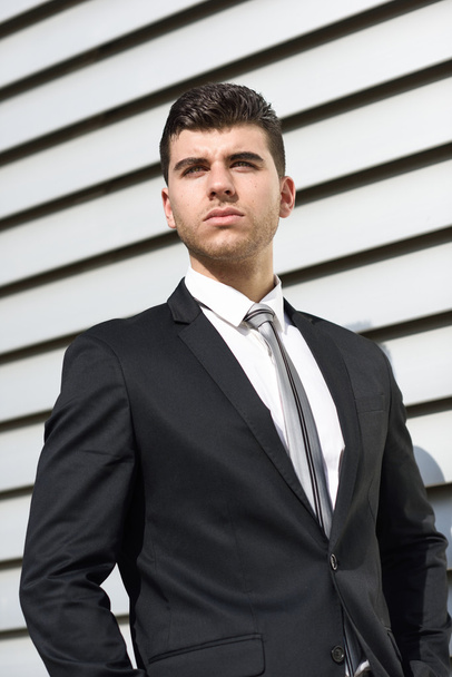 黒いスーツを着てオフィスビル近くの青年実業家 - 写真・画像