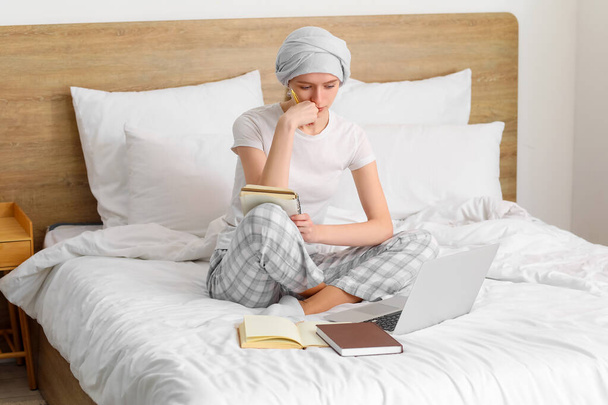 Teenage girl after chemotherapy studying online in bedroom - Foto, Bild