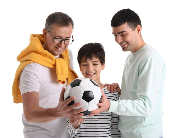 Счастливый маленький мальчик с отцом и дедушкой держит футбольный мяч на белом фоне - Фото, изображение