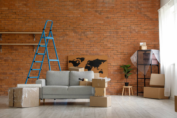 Pohovka s kartónovými krabicemi a žebříkem v obývacím pokoji v den stěhování - Fotografie, Obrázek