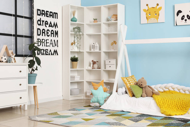 Interieur kinderkamer met bed, plank en speelgoed - Foto, afbeelding