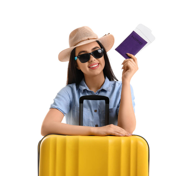 Young woman with passport and yellow suitcase on white background - Photo, Image