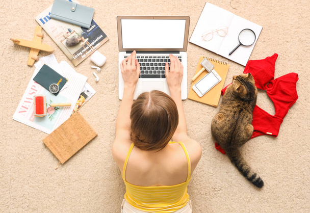 Γυναίκα με Scottish fold cat και αξεσουάρ ταξιδιού με laptop σε μπεζ χαλί, top view - Φωτογραφία, εικόνα