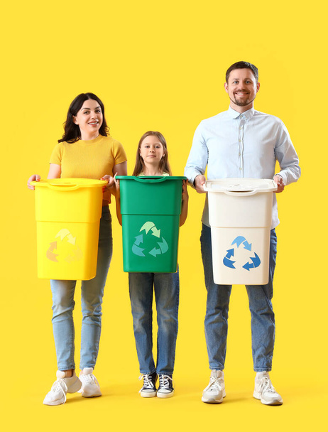 Family with recycle bins on yellow background - Photo, Image