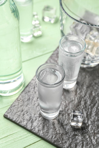 Glasses of cold vodka on green wooden background - Photo, image