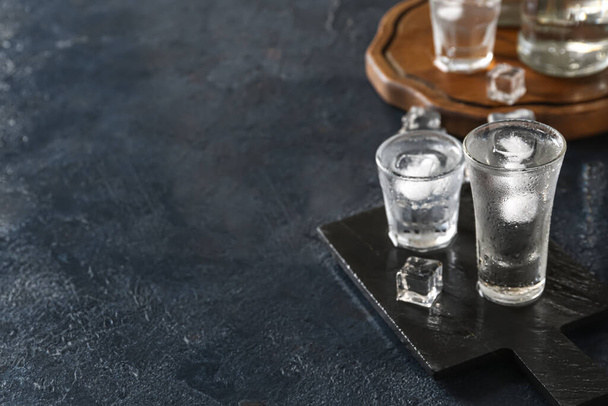 Karanlık masanın üstünde votka kadehleriyle tahtalar - Fotoğraf, Görsel