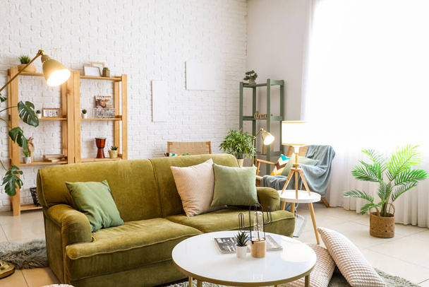 Sisätilojen olohuone hehkulamput, sohva ja huonekasvit - Valokuva, kuva