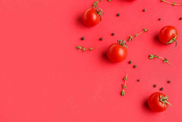 Composition with ripe cherry tomatoes, thyme and peppercorn on red background - Valokuva, kuva