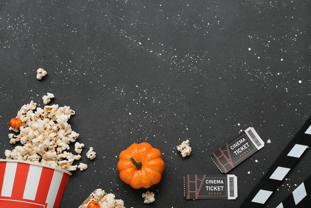 Kompozice s chutným popcornem, dýní a vstupenkami do kina na tmavém pozadí. Halloween oslava - Fotografie, Obrázek