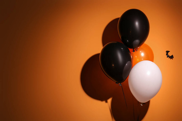 Halloween balloons and bat hanging on orange wall in room - Photo, Image