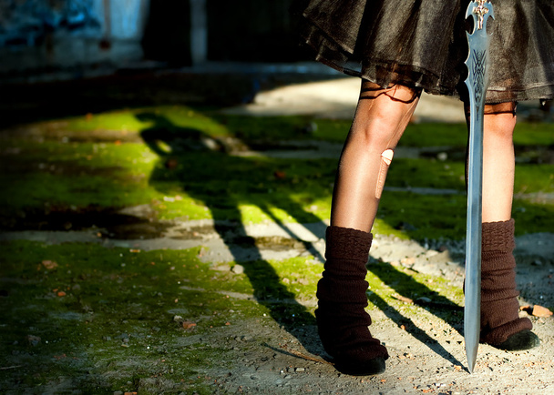 τα πόδια σκούρα goth κορίτσι με σπαθί στα χέρια της - Φωτογραφία, εικόνα