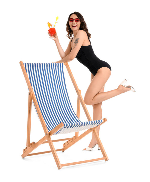 Young woman with cocktail and deck chair on white background - Photo, Image