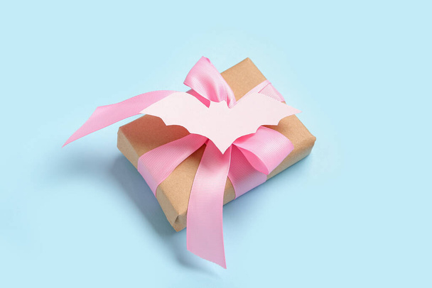 Красива подарункова коробка і кажан з паперу для Хеллоуїна на синьому фоні, крупним планом - Фото, зображення