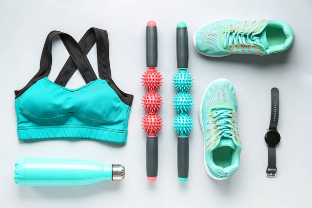 Composición con ropa deportiva, zapatos, equipo y smartwatch sobre fondo claro - Foto, Imagen
