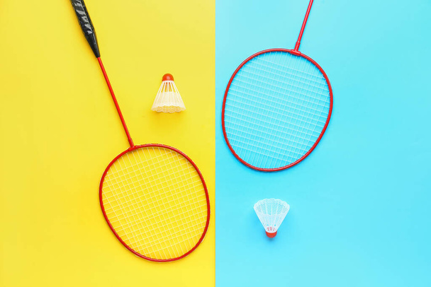 Badminton shuttledoppen en rackets op kleur achtergrond - Foto, afbeelding