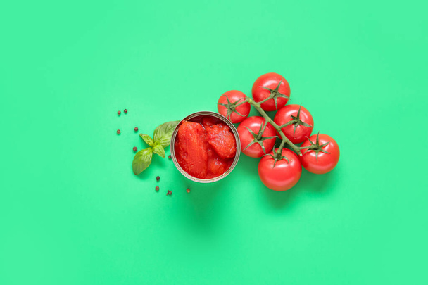 Enlatados, tomates frescos y especias sobre fondo verde - Foto, imagen