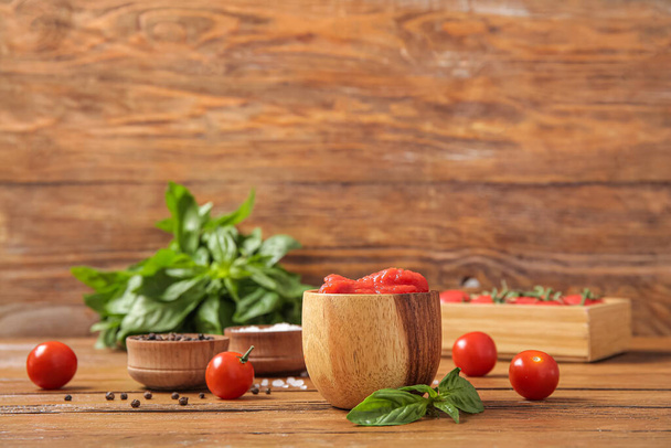缶詰トマト,スパイス,木製テーブルの新鮮なバジルのボウル - 写真・画像