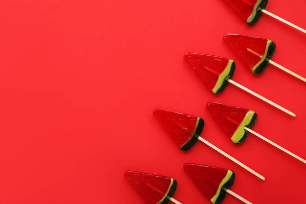 Леденцы в форме ломтика арбуза на красном фоне - Фото, изображение