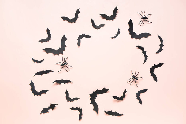 Σκελετός από χάρτινες νυχτερίδες και αράχνες για αποκριάτικο πάρτι σε ροζ φόντο - Φωτογραφία, εικόνα