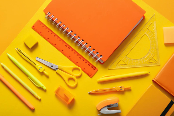 Különböző iskolai írószerek és notebook színes háttér - Fotó, kép