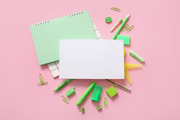 Композиція з чистим аркушем паперу та різними шкільними канцелярськими приладдям на рожевому фоні - Фото, зображення