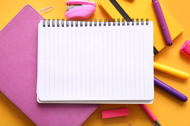 Composition with blank notebook and different school stationery on orange background, closeup - Photo, Image