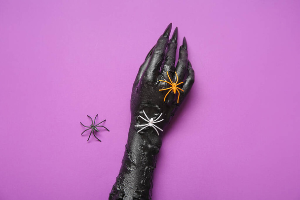 Musta käsi noita ja hämähäkit violetti tausta. Halloween juhla - Valokuva, kuva
