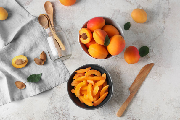 Bowl with pieces of sweet apricots on white table - Photo, Image