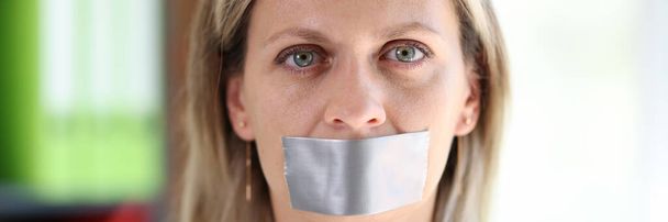 Woman face close up with gray adhesive tape covering mouth. Concept of unfreedom, censorship and silence. - Photo, image