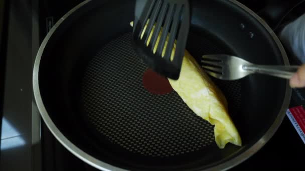 Çırpılmış yumurta, omlet, siyah tavayla kahvaltı hazırlama, yavaşça kızarmış yumurta sahnesi. - Video, Çekim