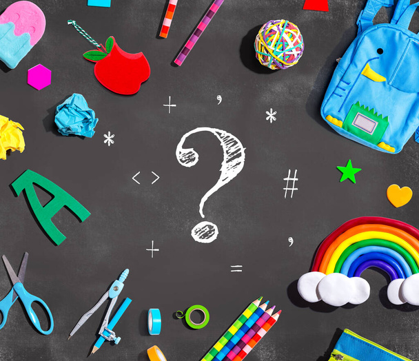 Question mark with school supplies on a chalkboard - flat lay - 写真・画像