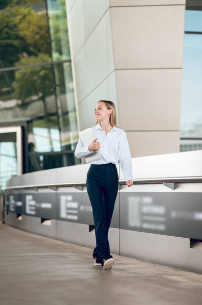 Business woman. Business woman in pants and white blouse walking iand looking confident - Foto, Imagem