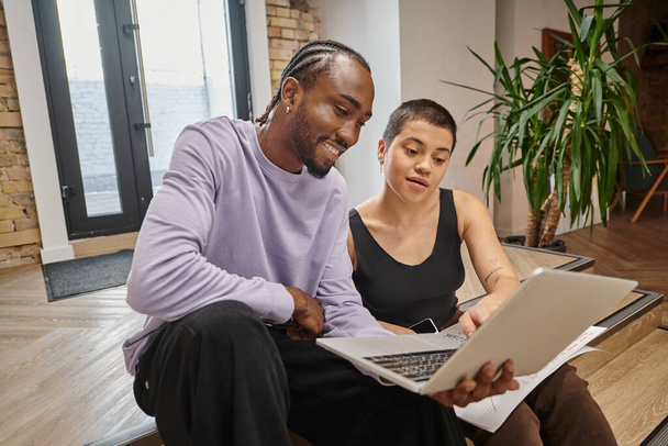 african american man showing project on laptop to woman, startup planning, ideas, coworking, gen z - Photo, Image
