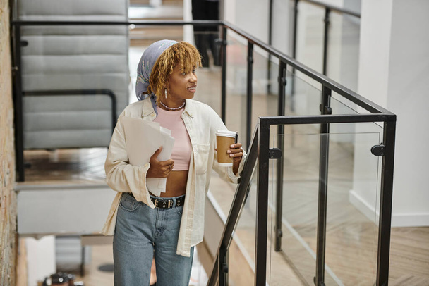 positive african american woman with braces holding papers, startup project, coworking, stairs - Photo, Image