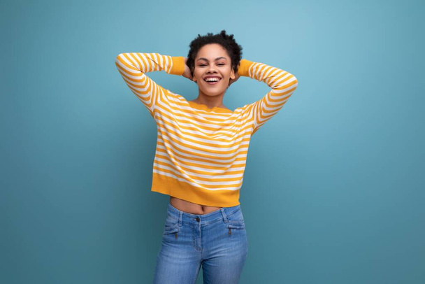 modèle optimiste latina jeune femme avec afro boucles sur fond de studio. - Photo, image