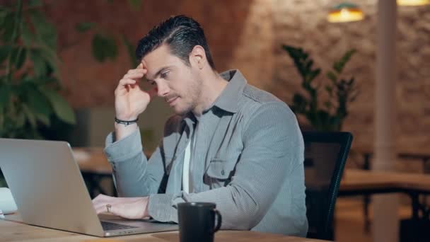 Video of handsome worried entrepreneur working with laptop in a coworking place - Video