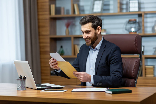 Happy successful boss received mail notification envelope with good news message, financier at workplace inside office, businessman happy with successful delivery results. - Fotoğraf, Görsel