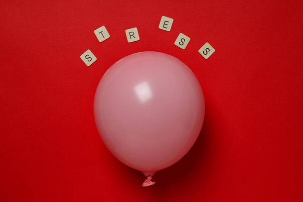 Balloon and word Stress on red background - Photo, image