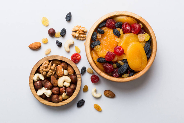 healthy snack: mixed nuts and dried fruits in bowl on table background, almond, pineapple, cranberry, cherry, apricot, cashew. - Photo, image