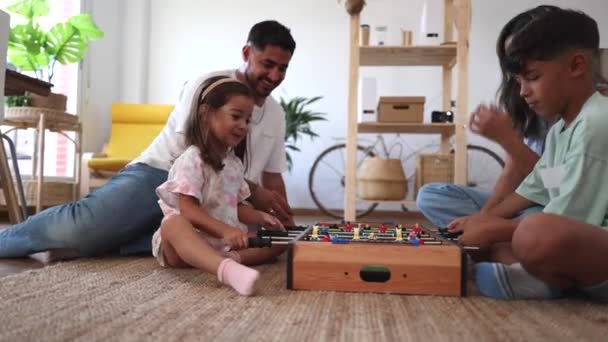 familia hispana jugando futbolín en casa - Imágenes, Vídeo